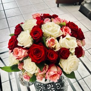Assemblage de 21 roses variées moyen bouton et gros bouton agrémentées de feuillage au choix du fleuriste