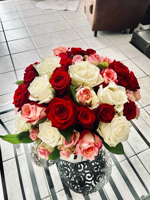 Assemblage de 21 roses variées moyen bouton et gros bouton agrémentées de feuillage au choix du fleuriste